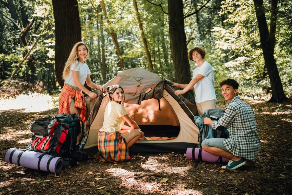 Ragazzi che montano una tenda durante un Summer Camp avventura nella natura
